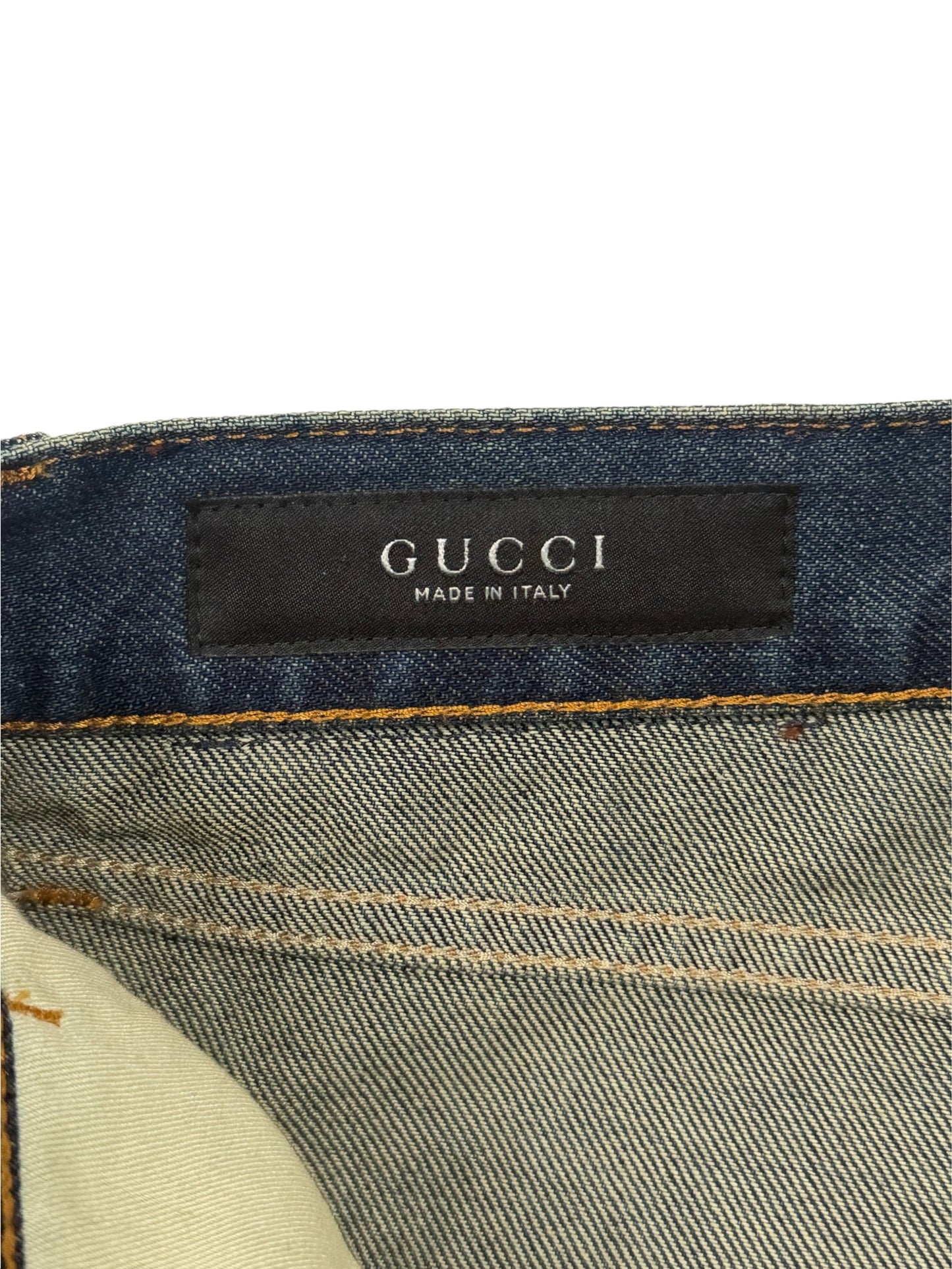 Gucci woven brand label on vintage wash cotton denim jeans