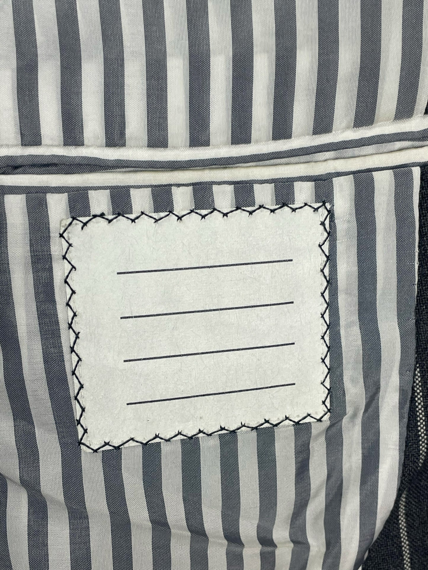 Grey and white striped interior lining of Thom Browne Ropestripe blazer