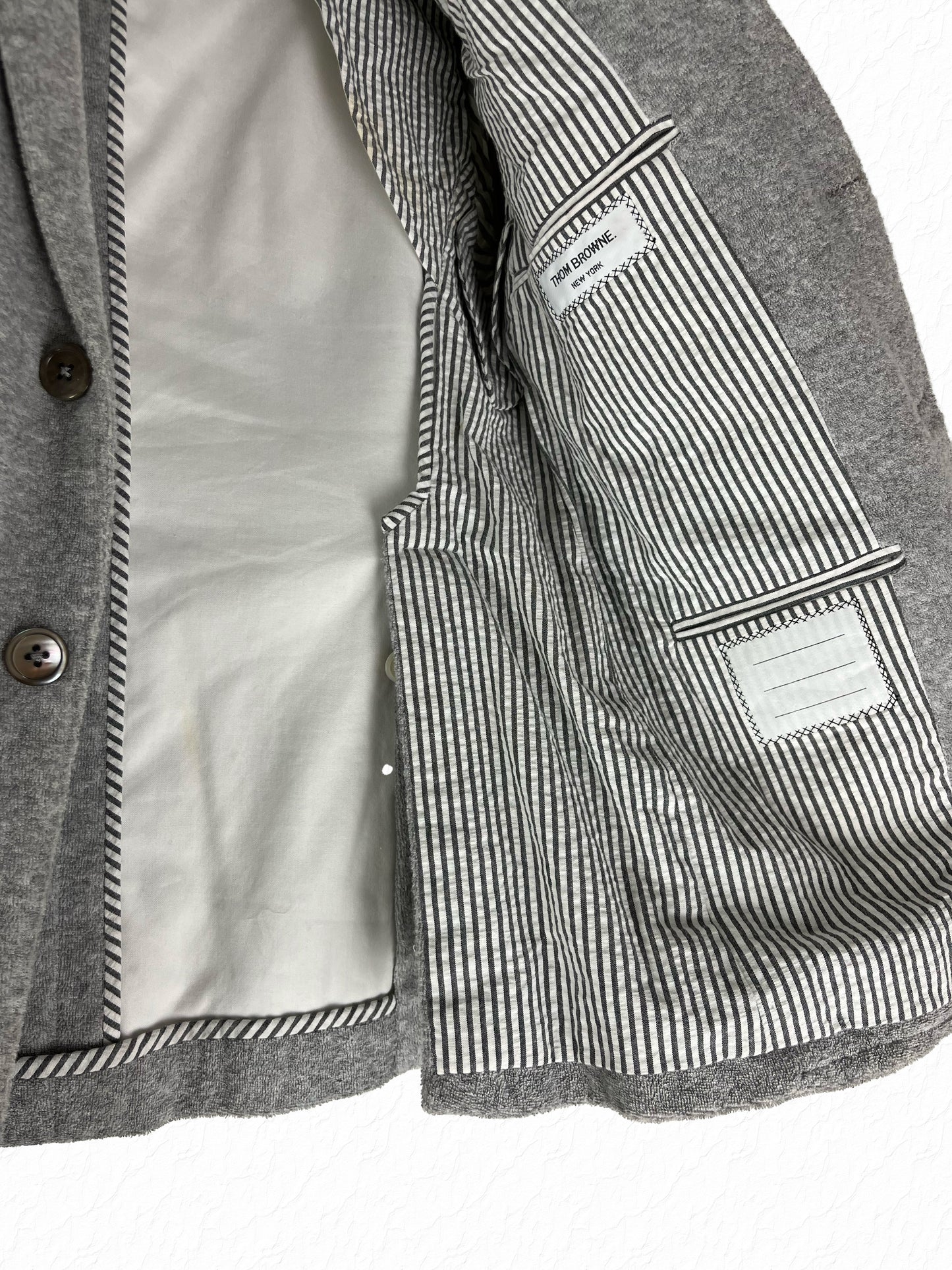 Striped seersucker lining with RWB grosgrain tab inside Thom Browne blazer