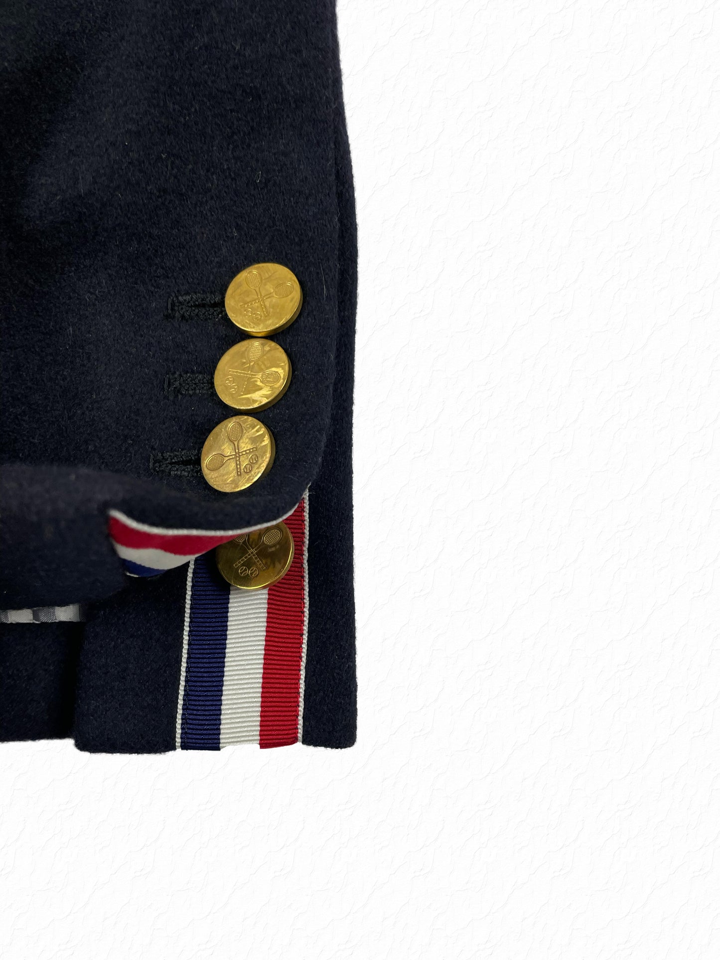 Gold tennis racket buttons on Thom Browne navy cashmere blazer
