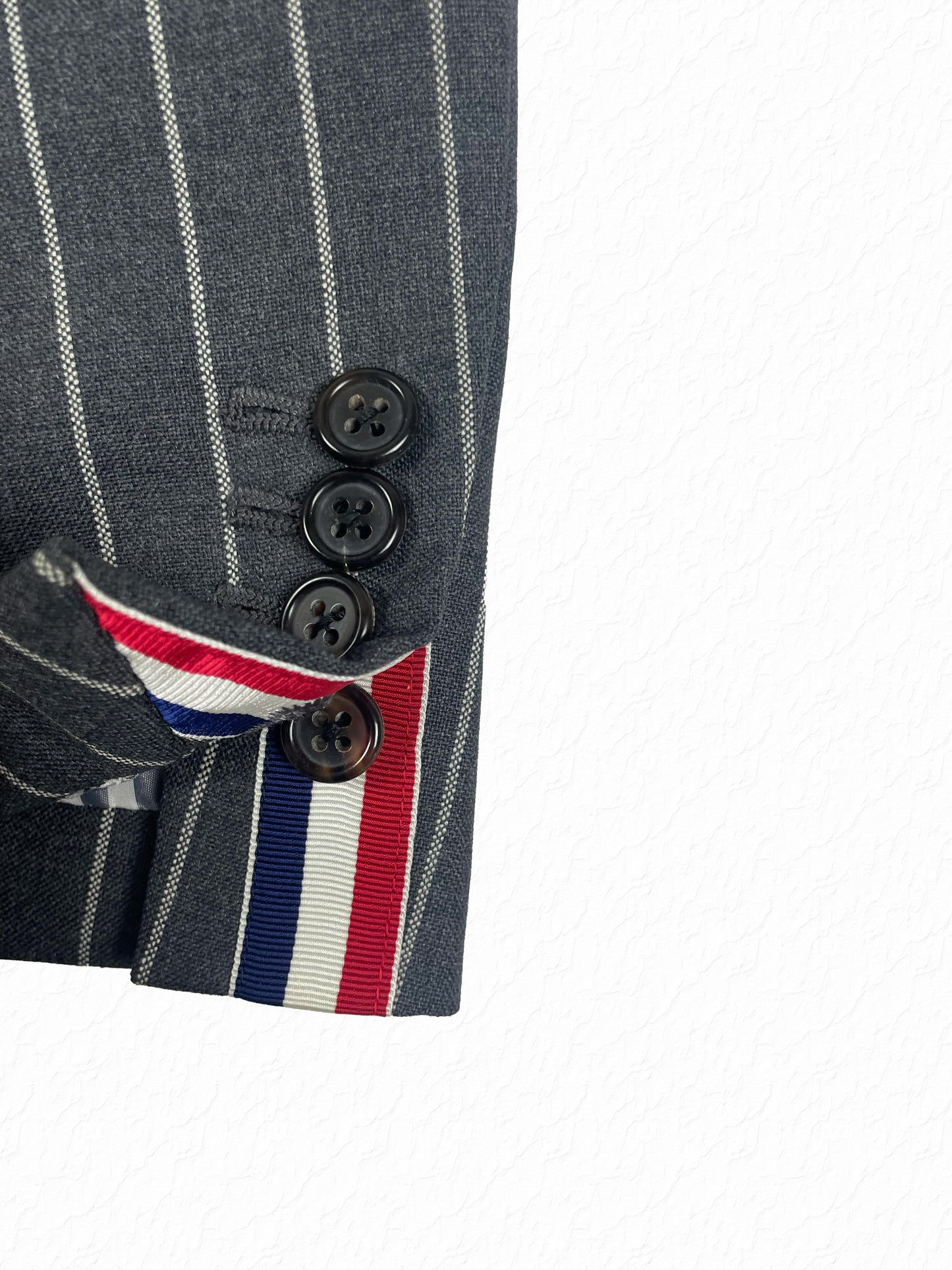 Grey chalk stripe wool blazer with red white and blue grosgrain cuff tab by Thom Browne