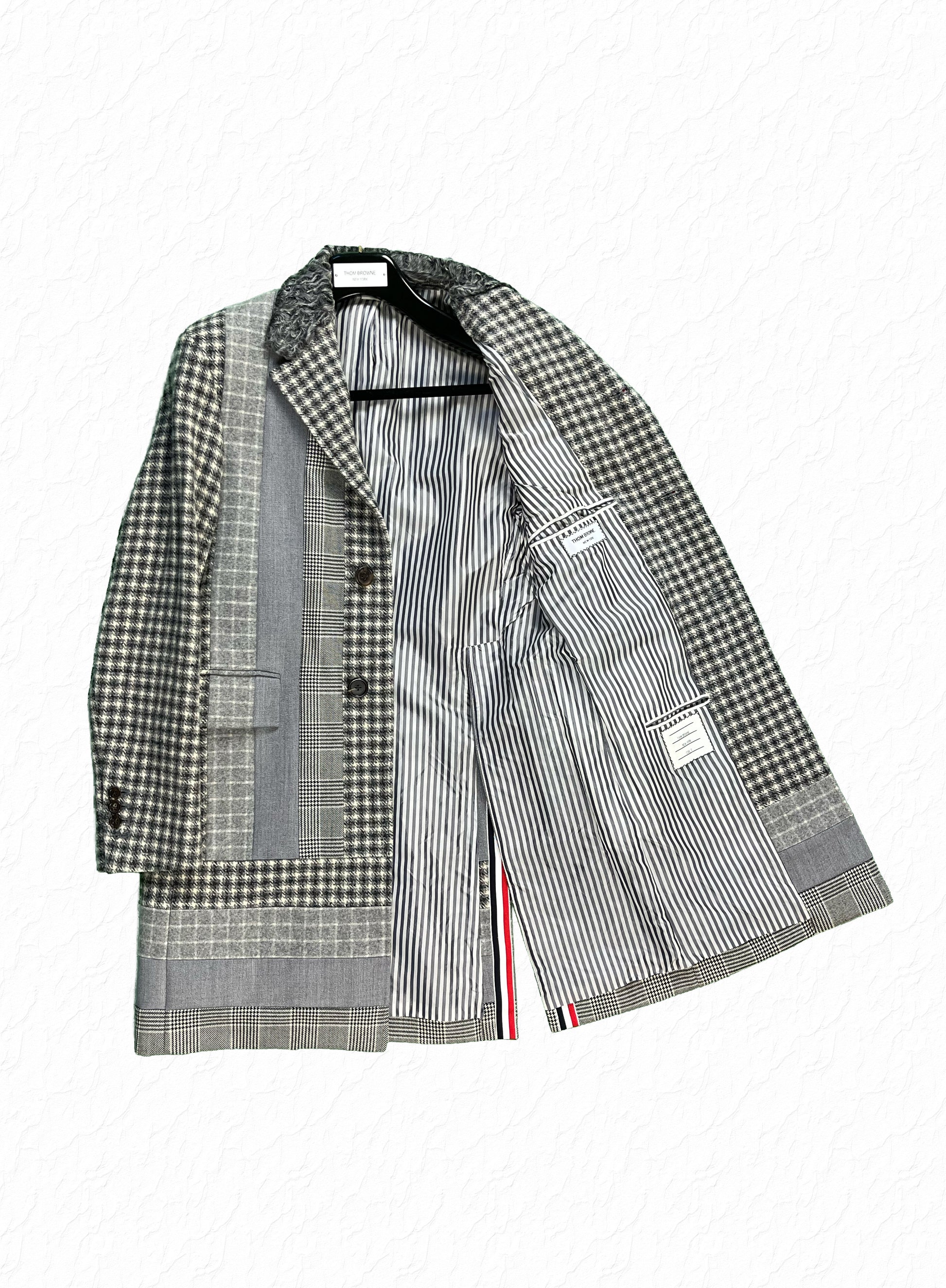 Grey houndstooth and glen plaid patchwork panels on Thom Browne wool overcoat