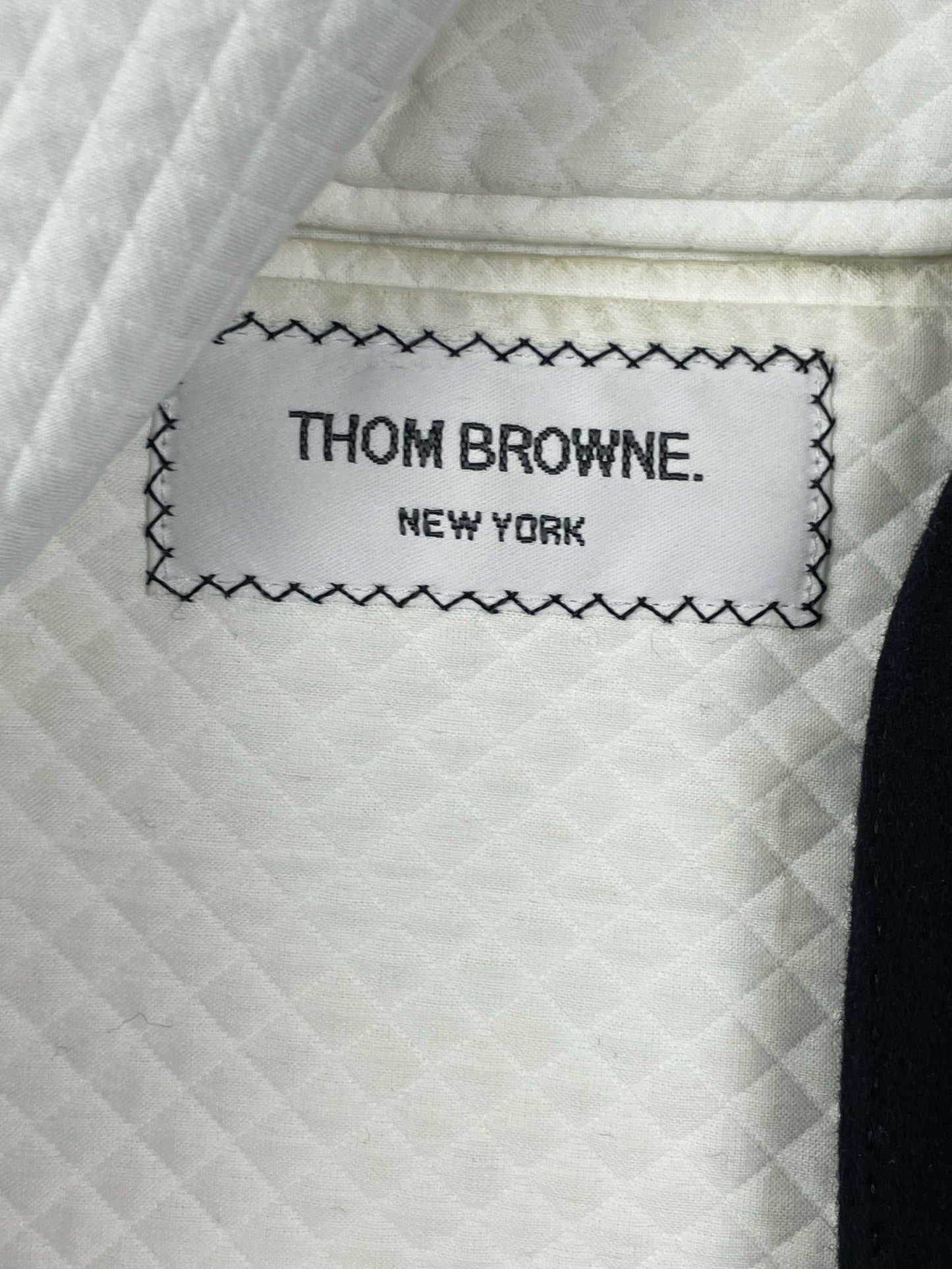 Thom Browne New York label on navy wool Chesterfield overcoat