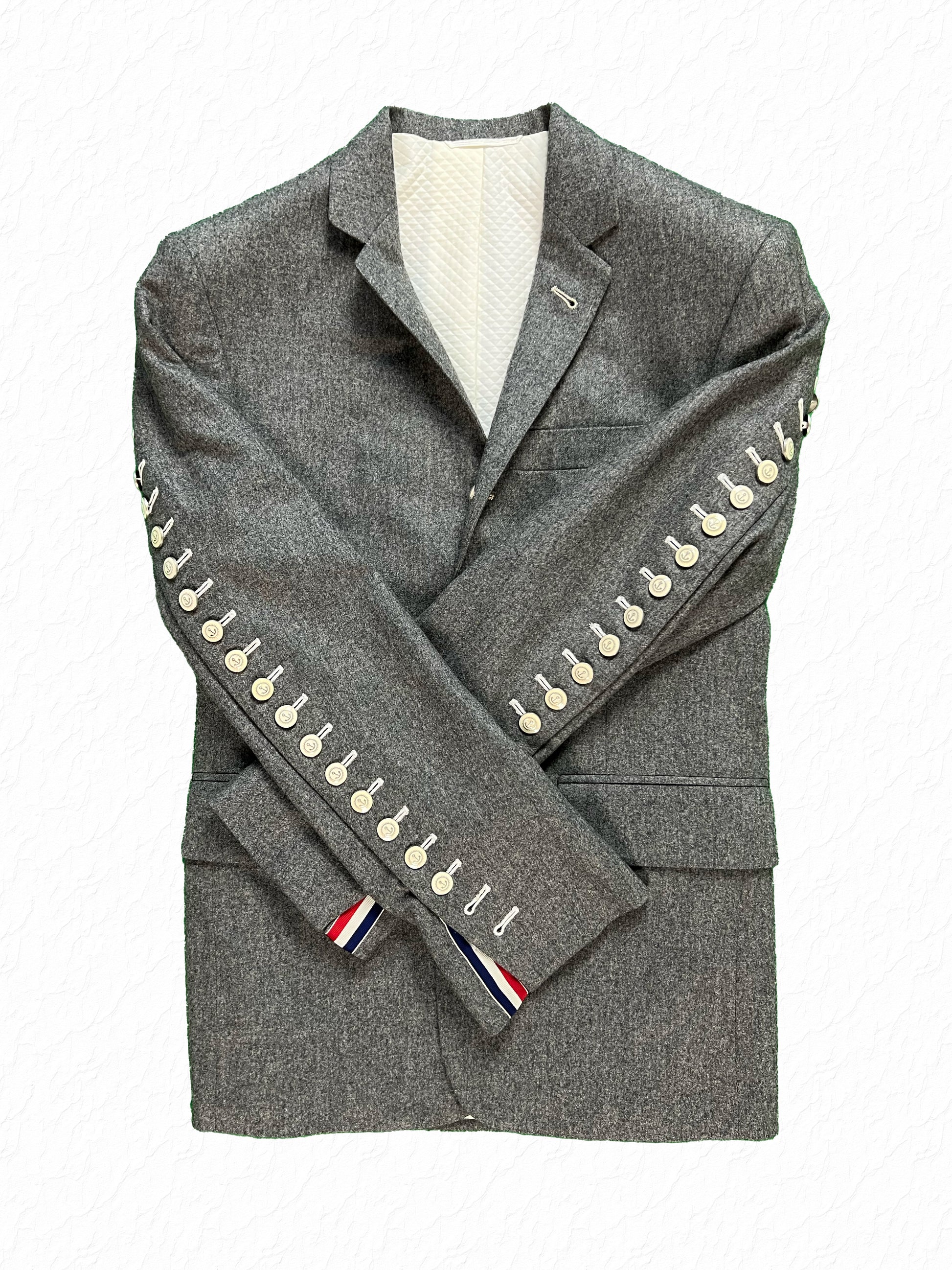 Functional arm fly buttons with RWB grosgrain tab on Thom Browne flannel jacket