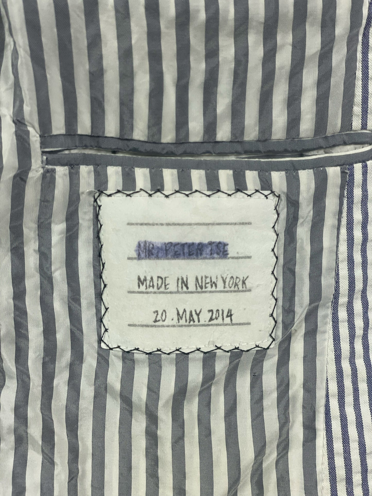 Grosgrain trimmed cuff buttons on archival Thom Browne seersucker jacket