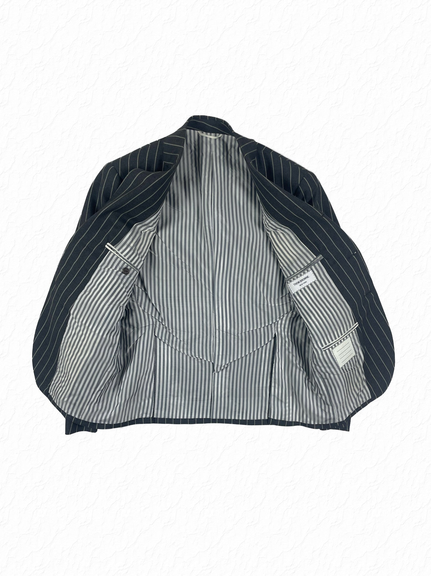 Ropestripe wool tailoring by Thom Browne in charcoal grey chalk stripe