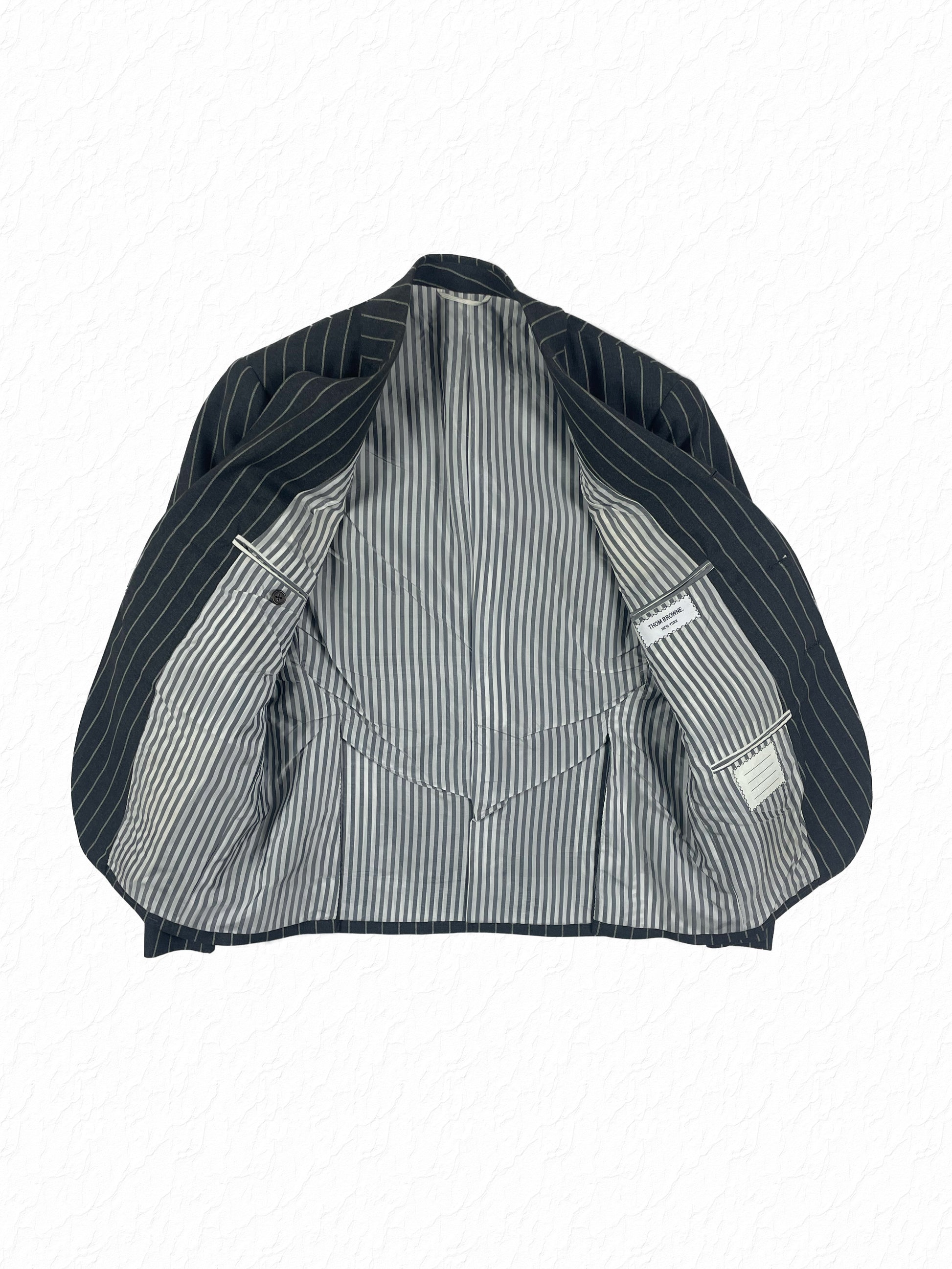Ropestripe wool tailoring by Thom Browne in charcoal grey chalk stripe