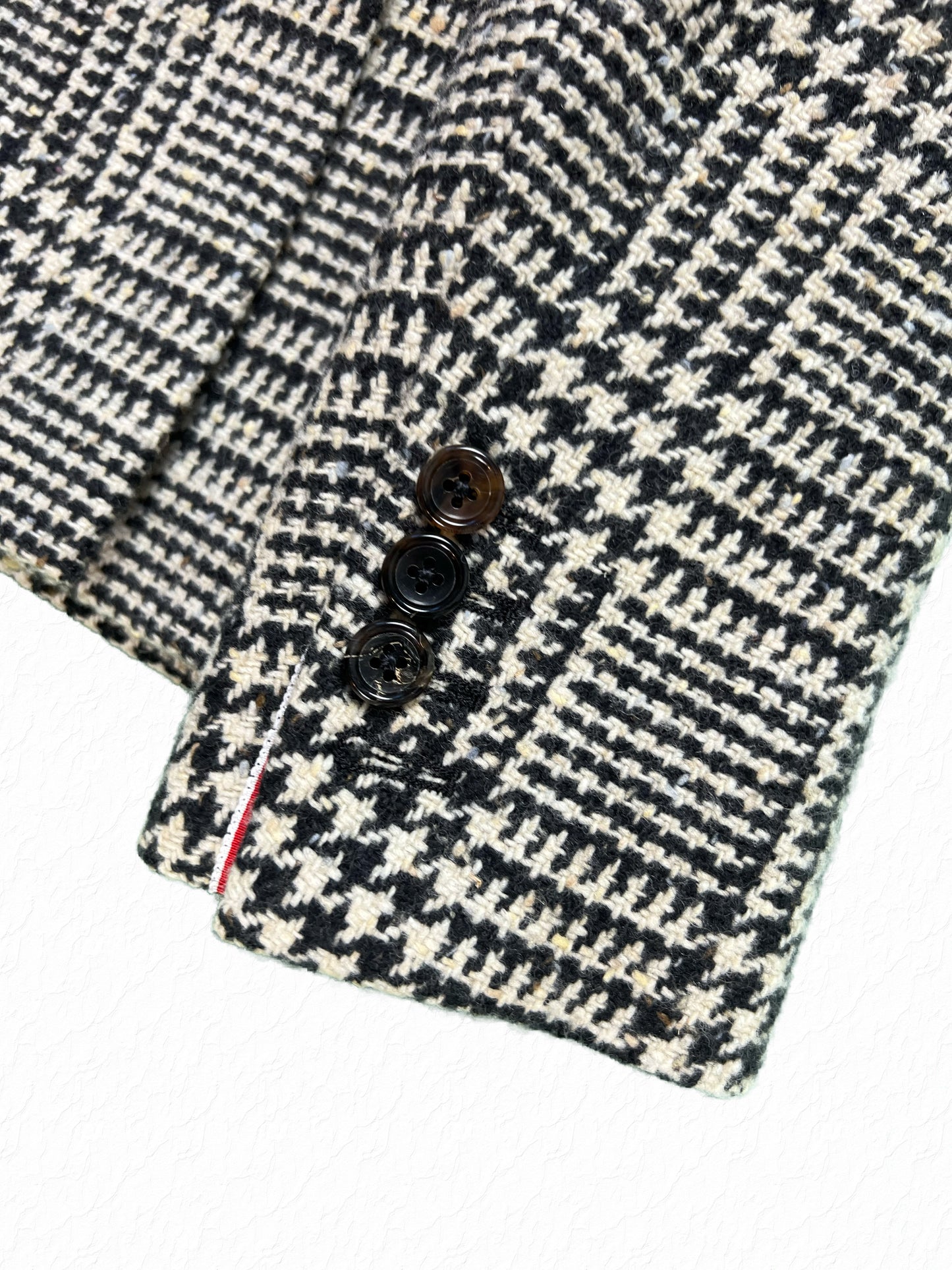 Thom Browne tortoise button cuff with tricolor grosgrain tab on tweed blazer