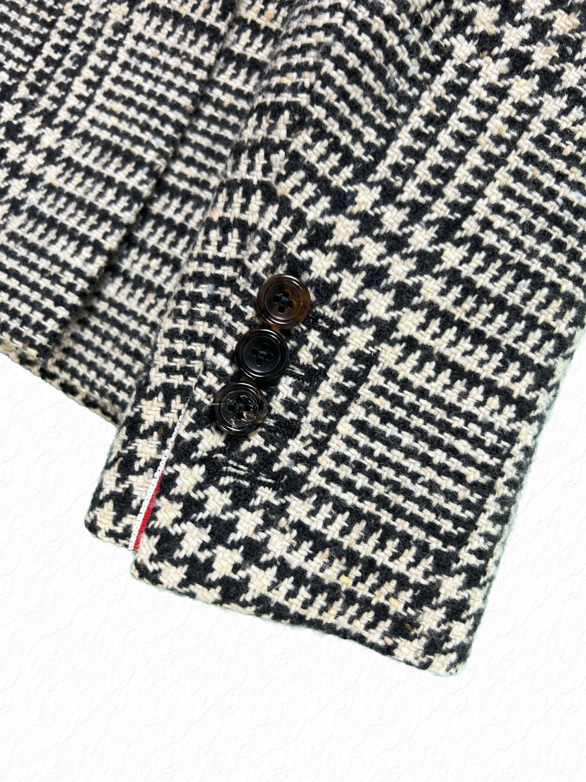 Thom Browne tortoise button cuff with tricolor grosgrain tab on tweed blazer