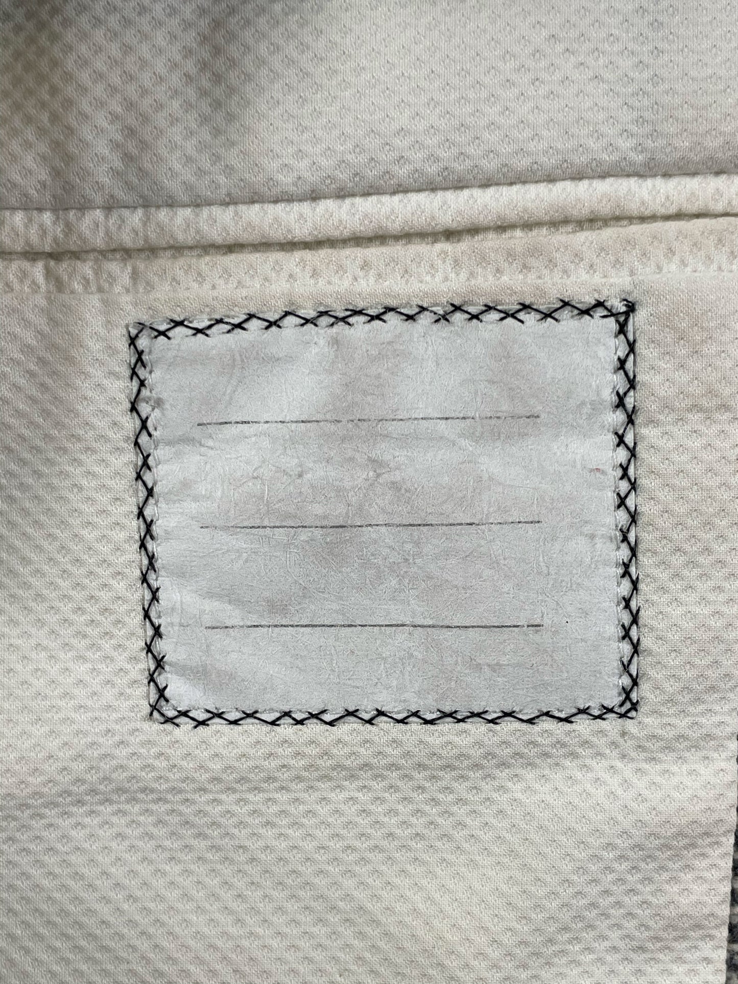 Cream interior lining of Thom Browne Fall 2005 tweed jacket