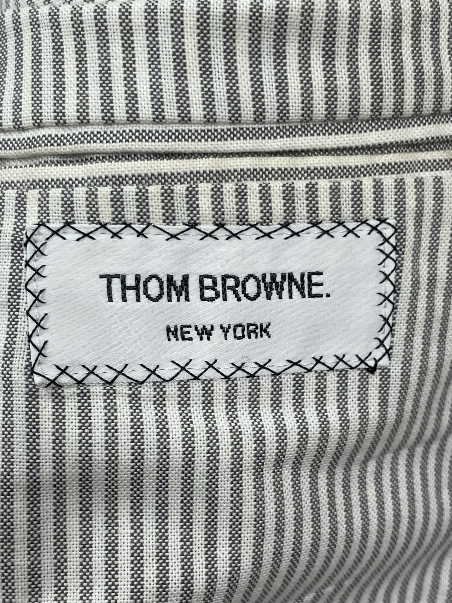 Grey striped cotton lining inside Thom Browne houndstooth wool overcoat