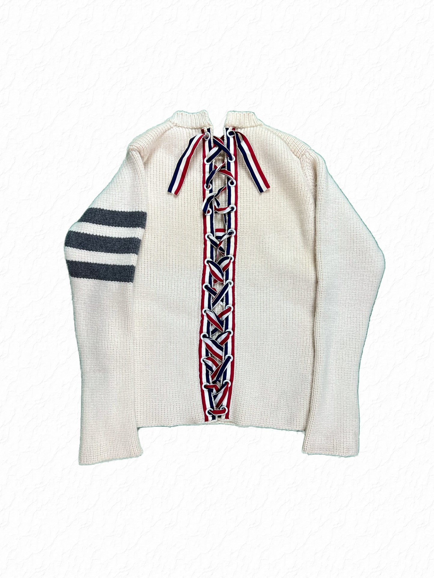 Cream cashmere Thom Browne sweater with red white blue grosgrain corset lacing