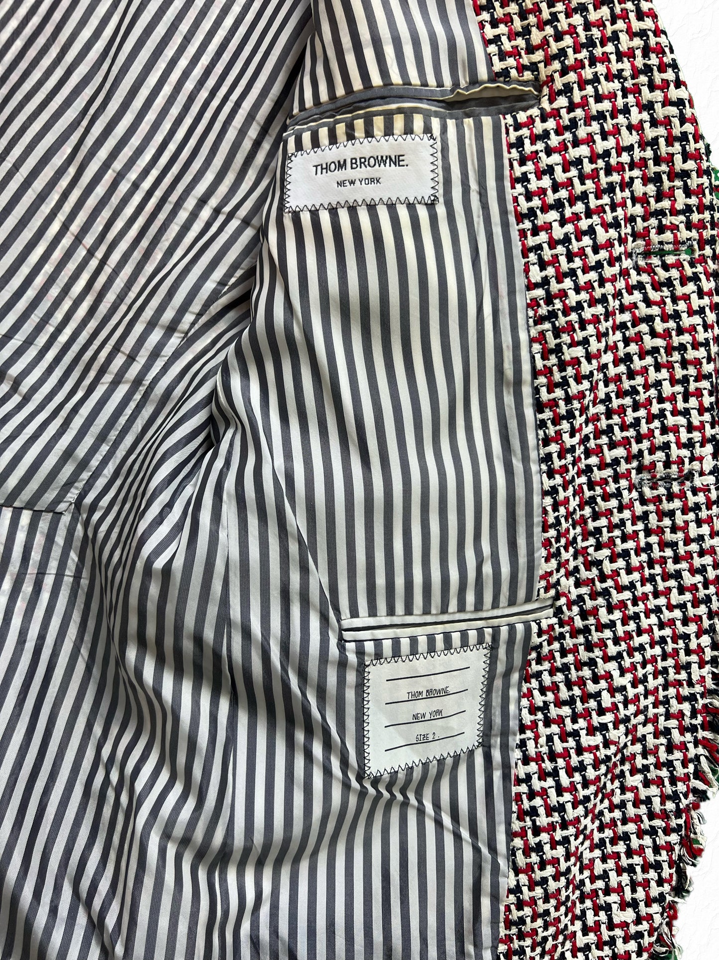 Frayed tufted seams on Thom Browne RWB rubber tweed jacket