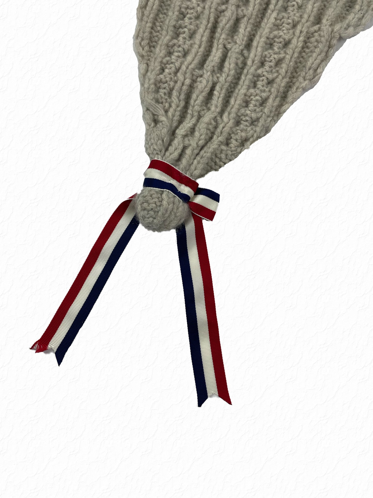 Grey cable knit cap by Thom Browne with tricolor red white and blue grosgrain knot