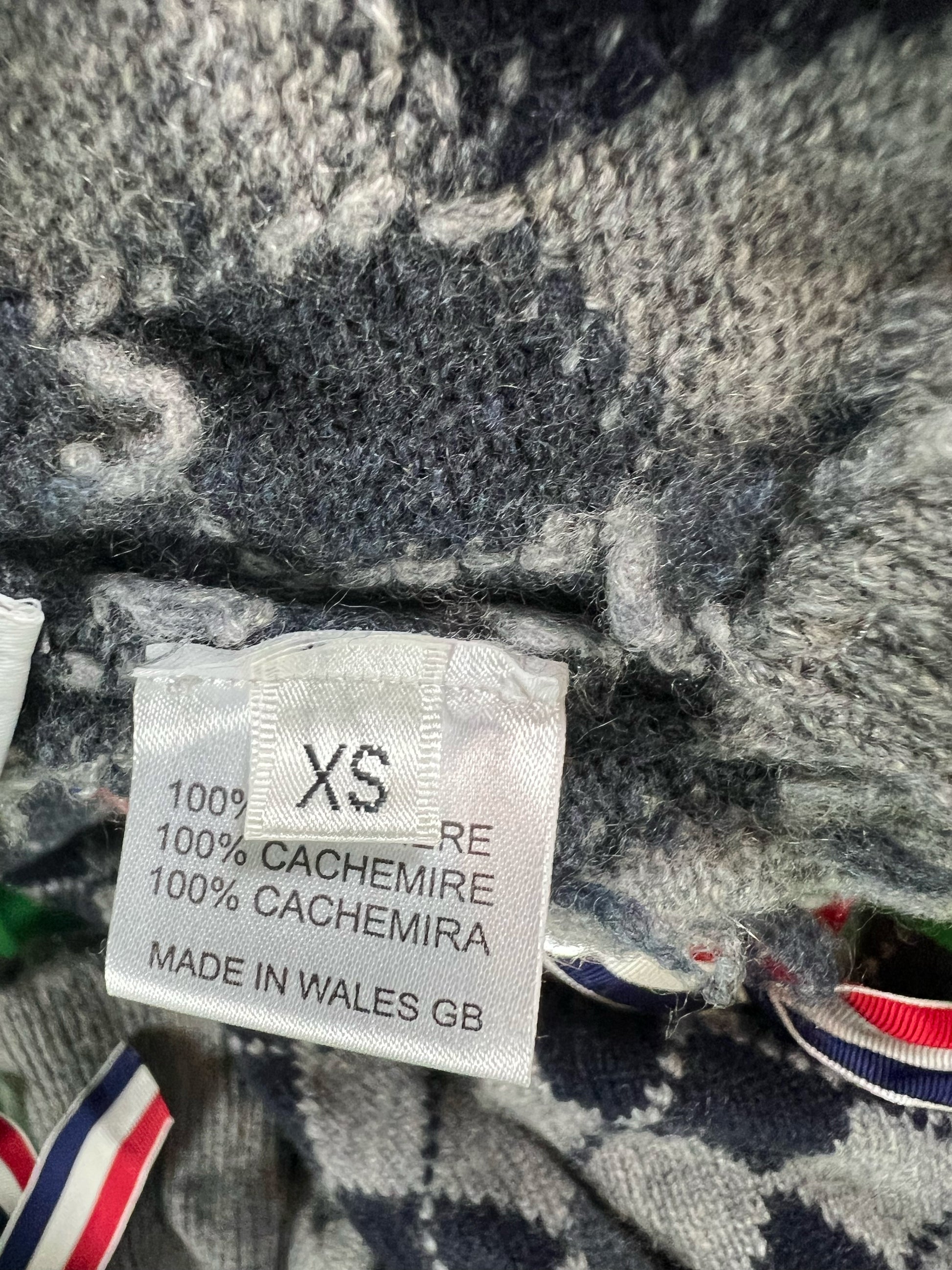 Argyle cashmere sweater with red white blue grosgrain corset lacing by Thom Browne