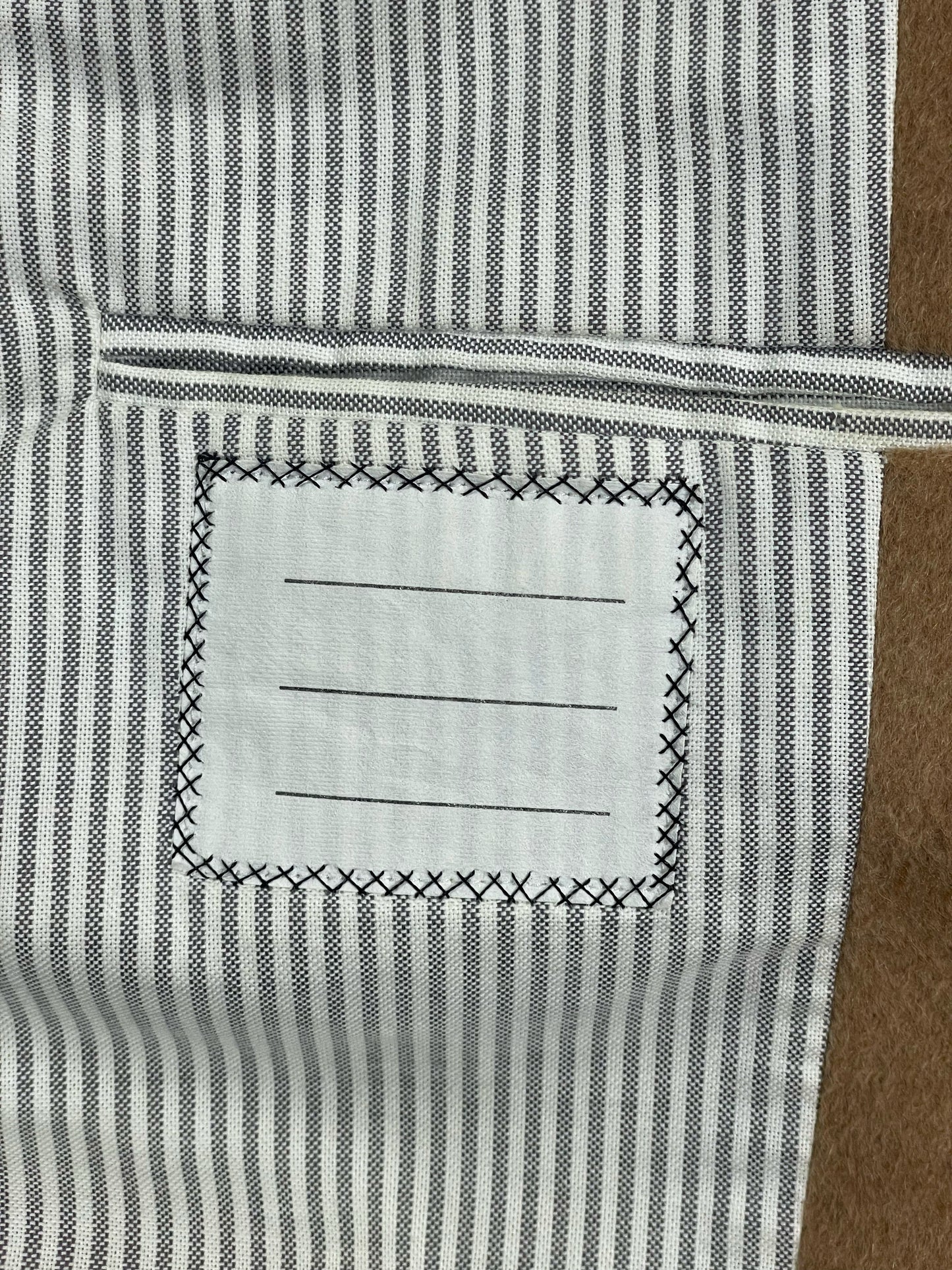 Striped cotton lining inside Thom Browne camel hair coat