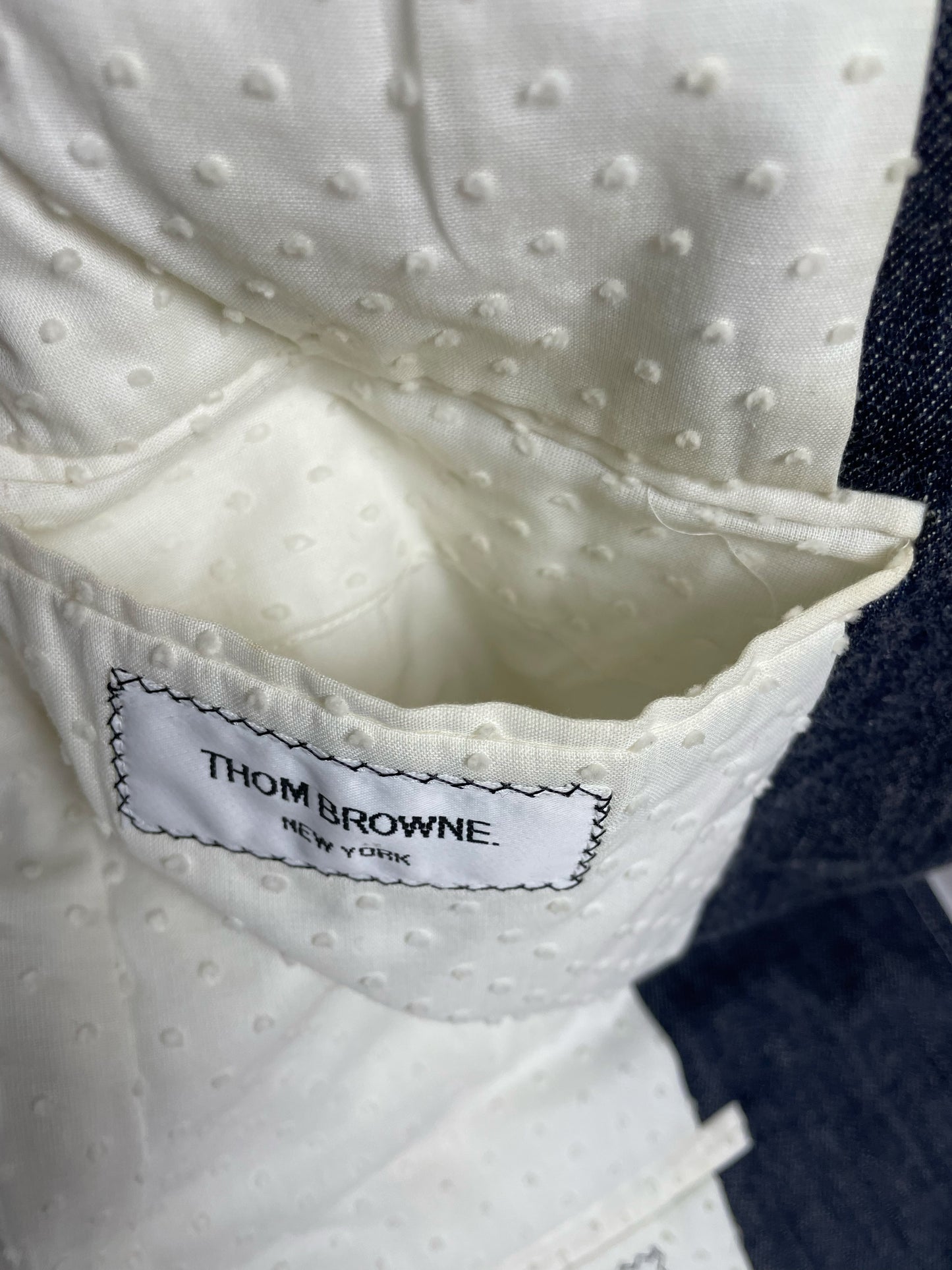 Thom Browne New York woven brand label on Japanese denim tailoring