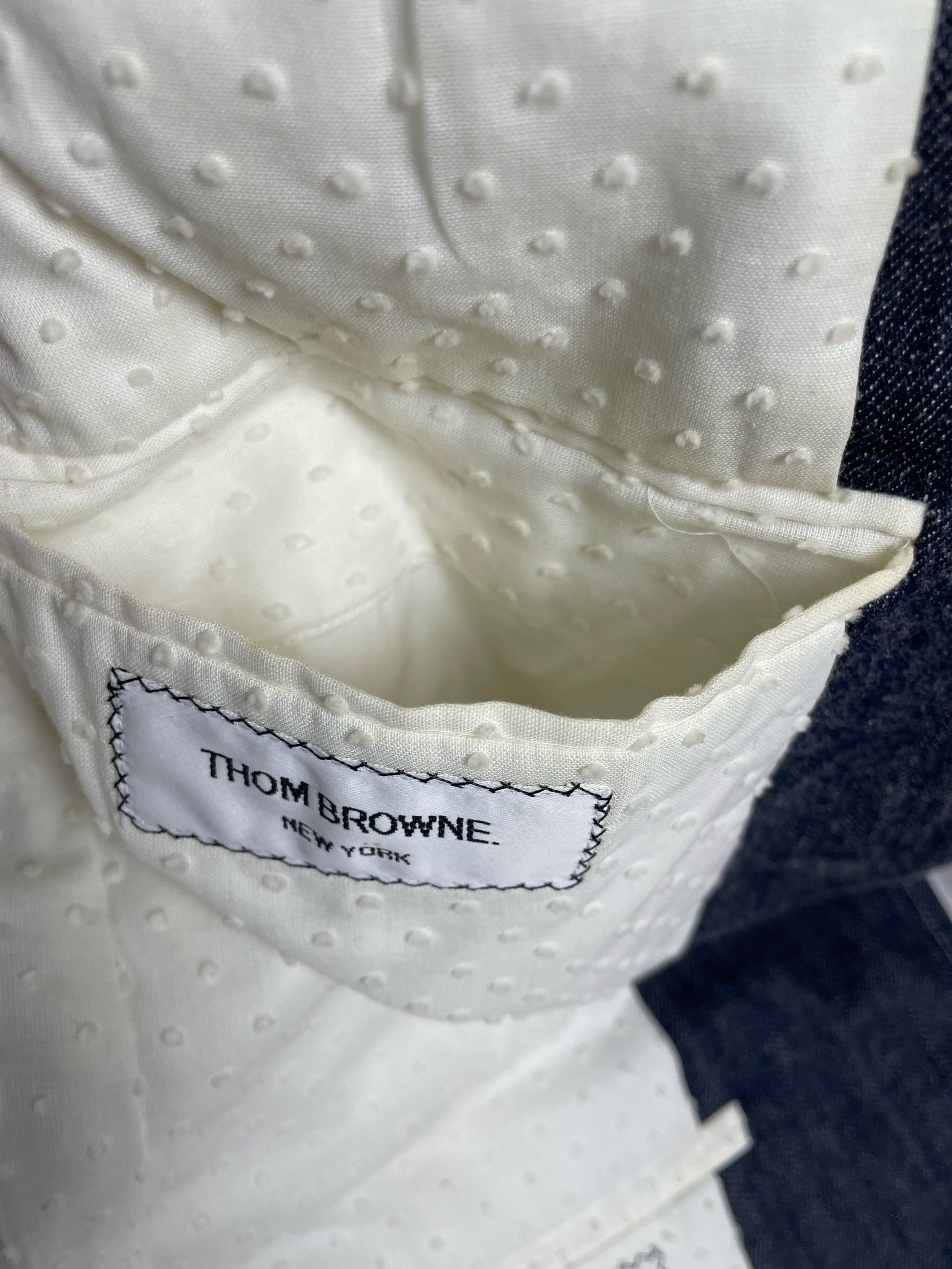 Thom Browne New York woven brand label on Japanese denim tailoring