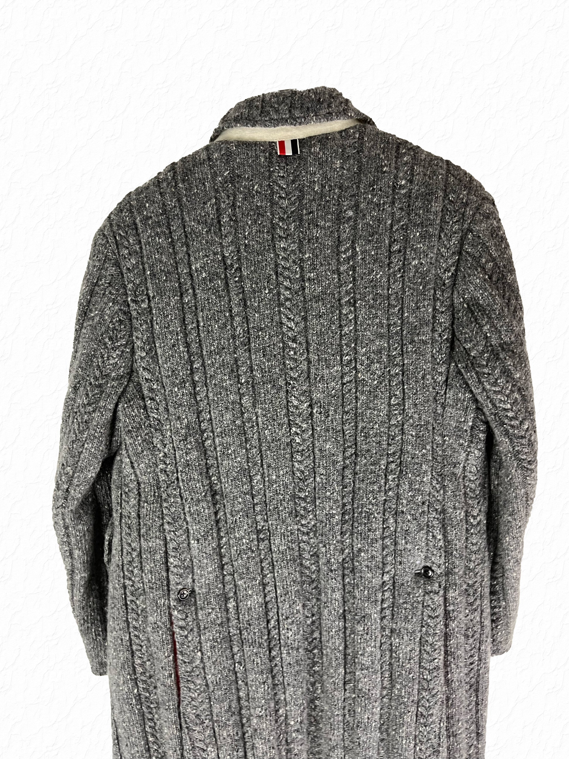 Cable knit Thom Browne overcoat with tonal horn buttons and RWB grosgrain tab
