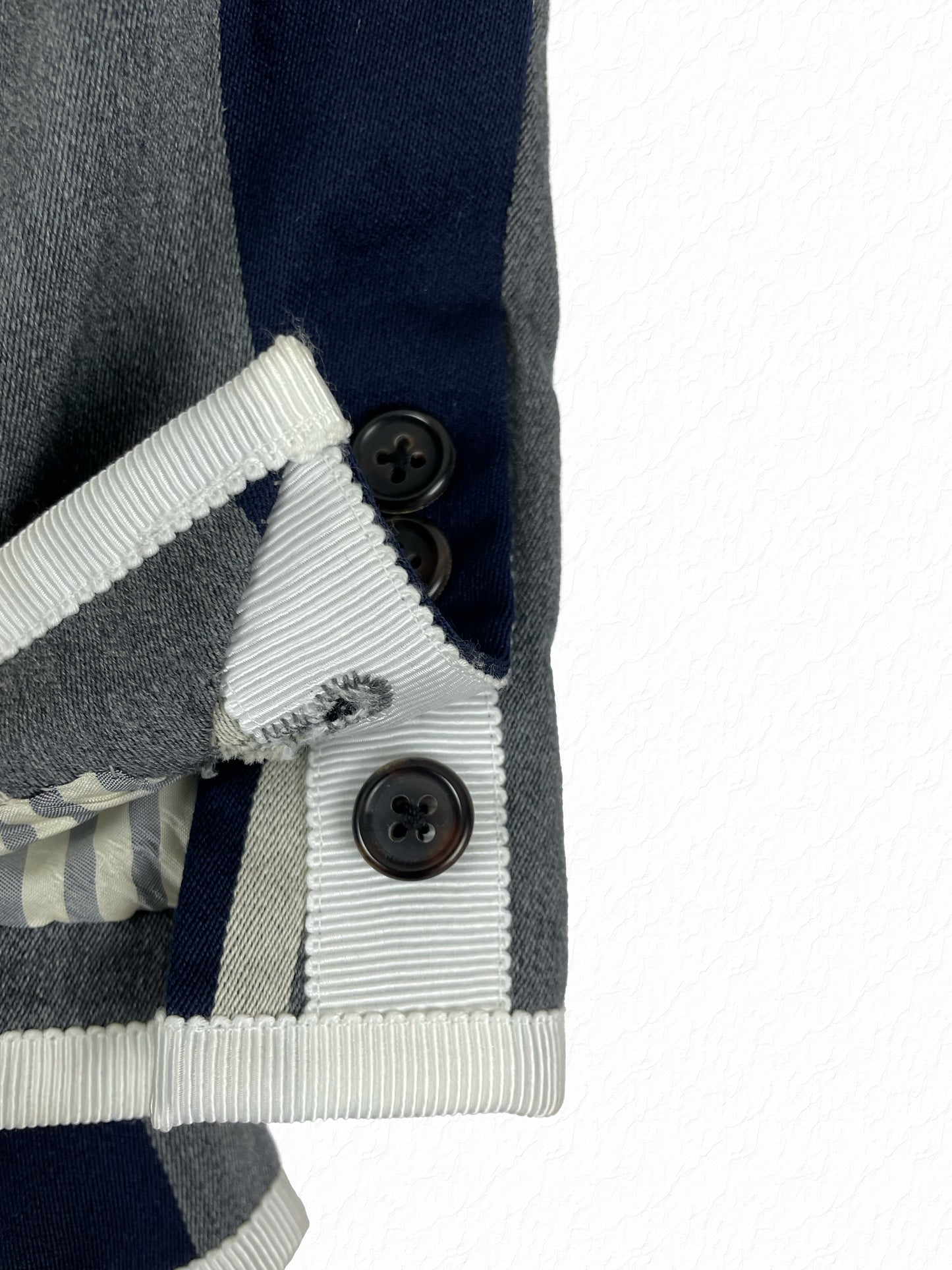 Four-button working cuff with white grosgrain trim on Thom Browne blazer