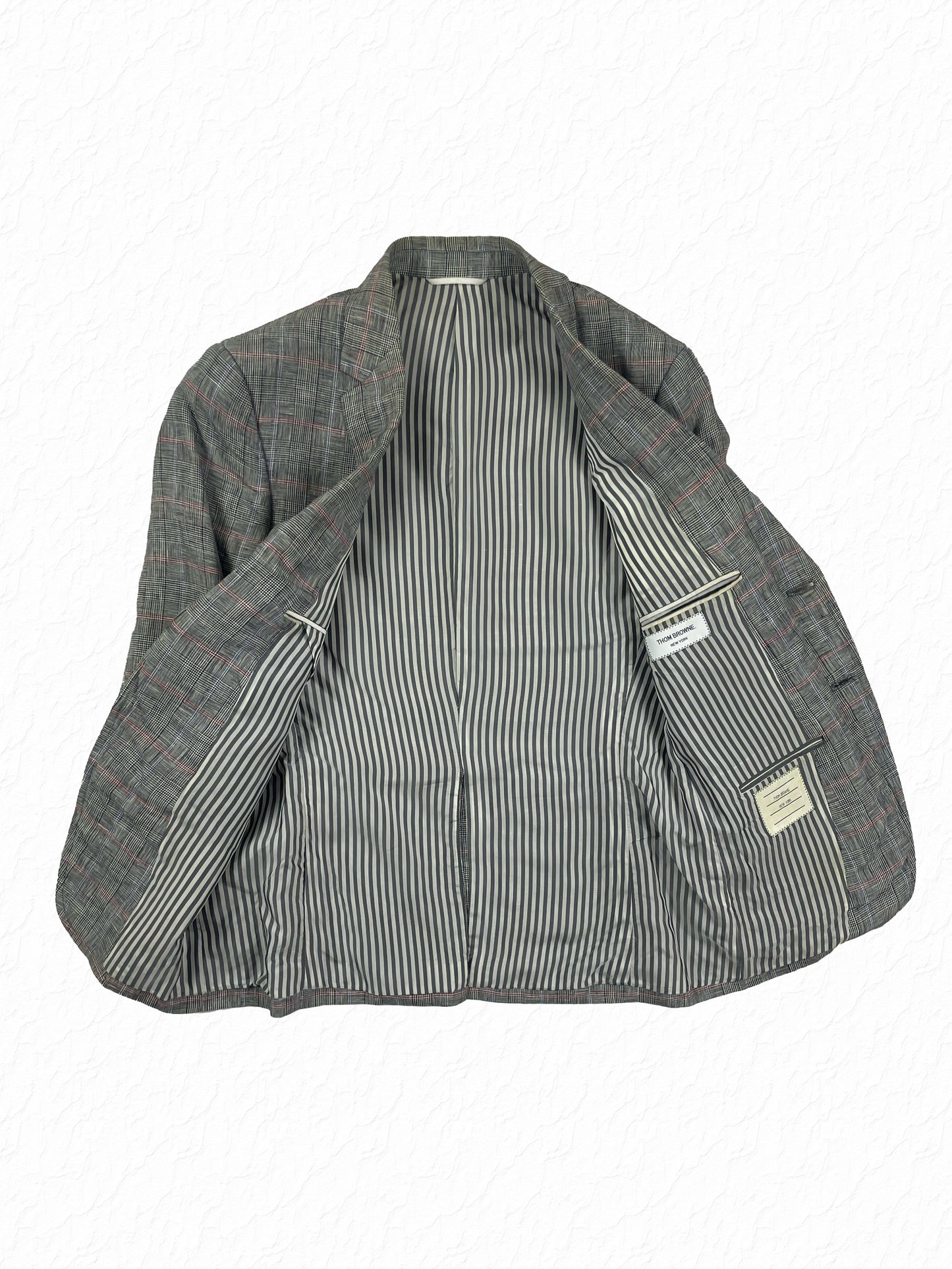 Signature grey and white striped lining on Thom Browne linen blazer