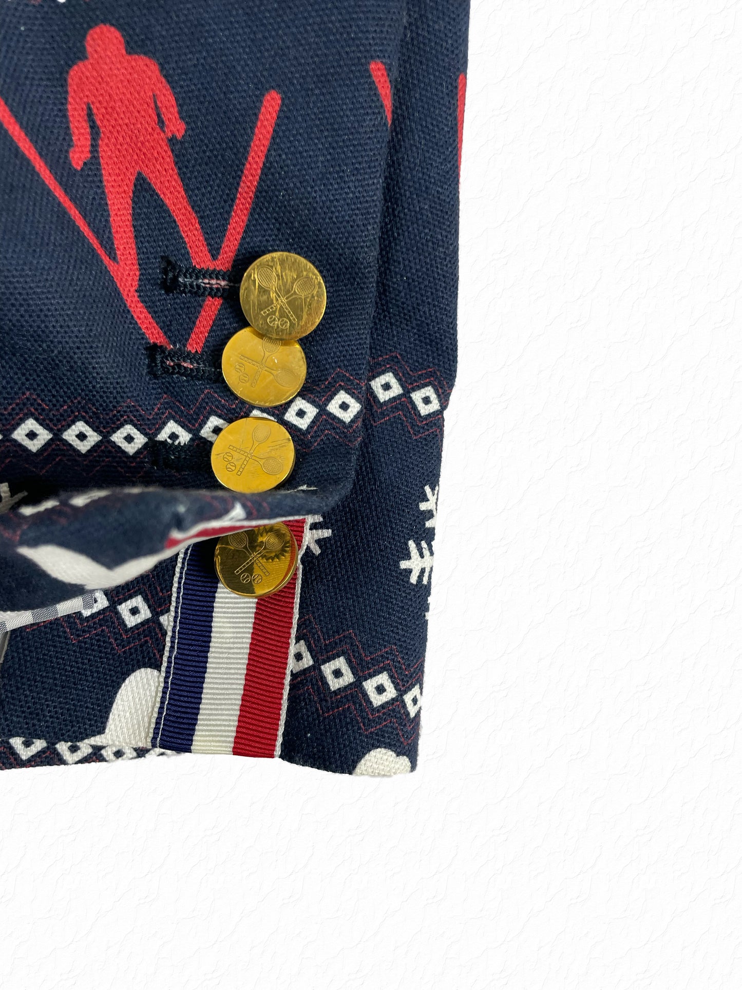 Gold tennis racket buttons on Thom Browne navy fair isle sport coat