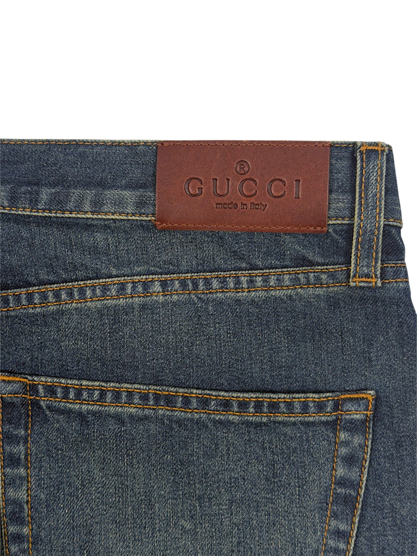 Gucci leather brand patch on blue denim jeans waistband