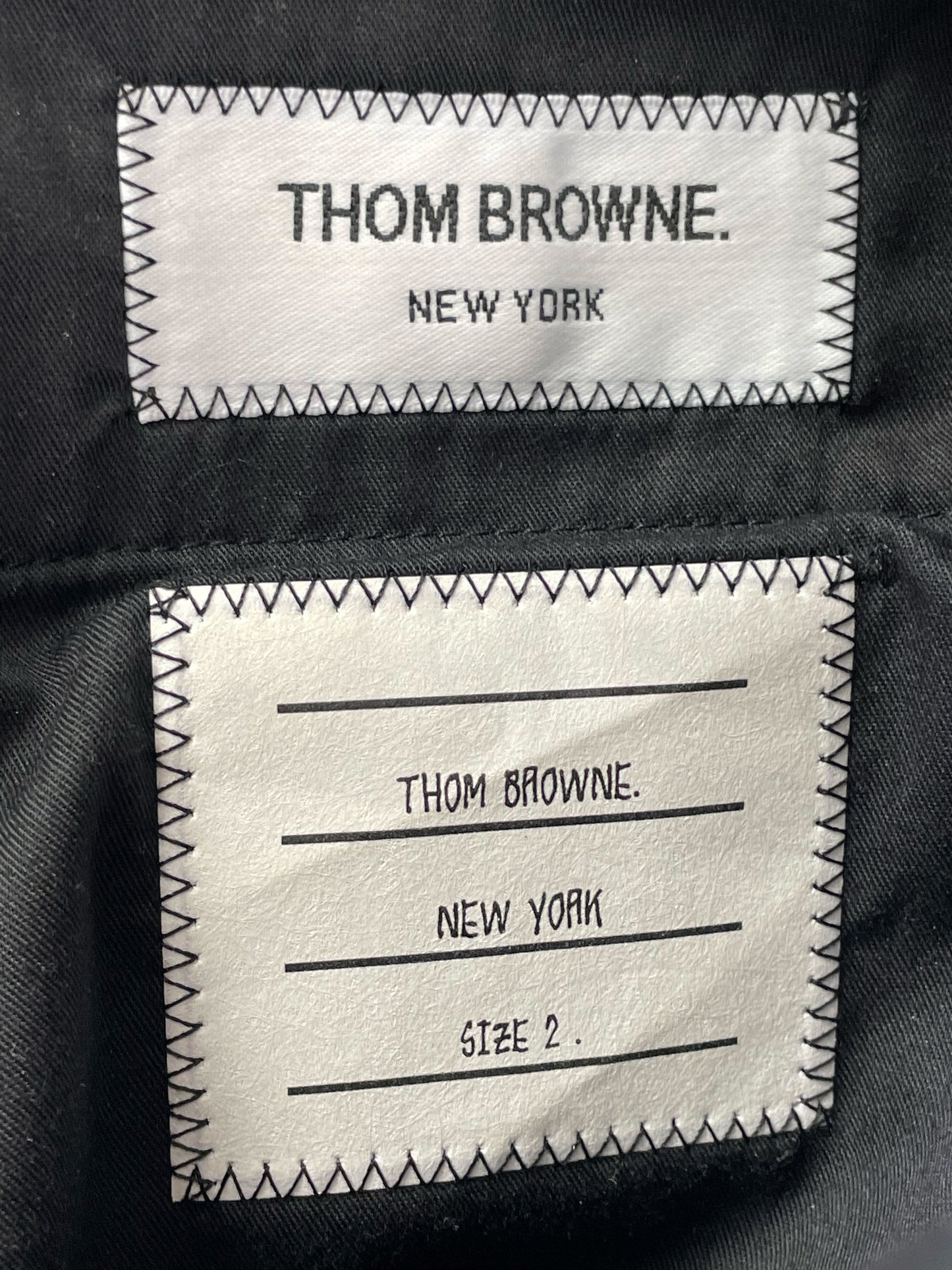 Thom Browne New York woven label on green tartan wool trousers