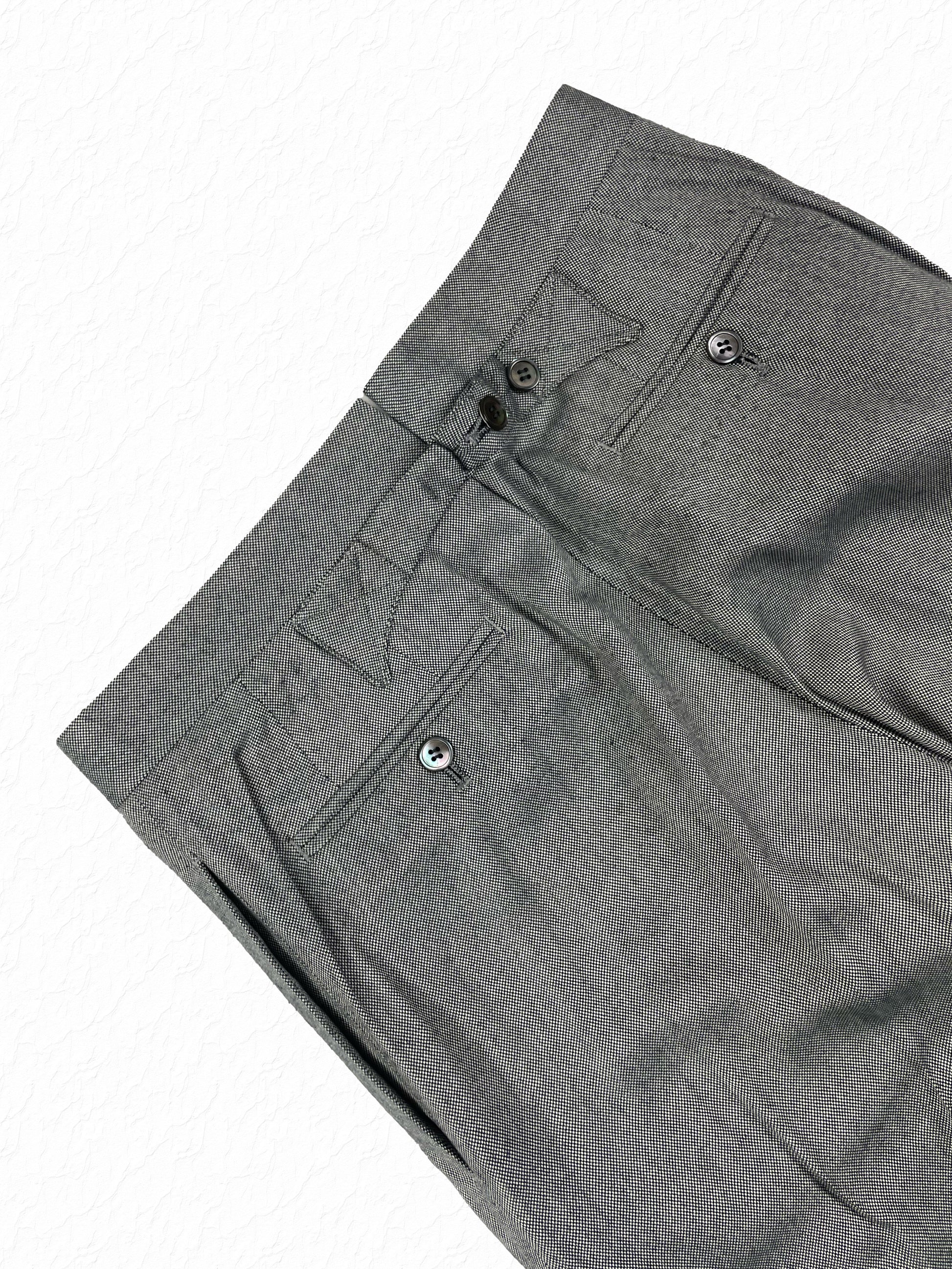 Buttoned welt pockets on Thom Browne salt and pepper cotton trousers