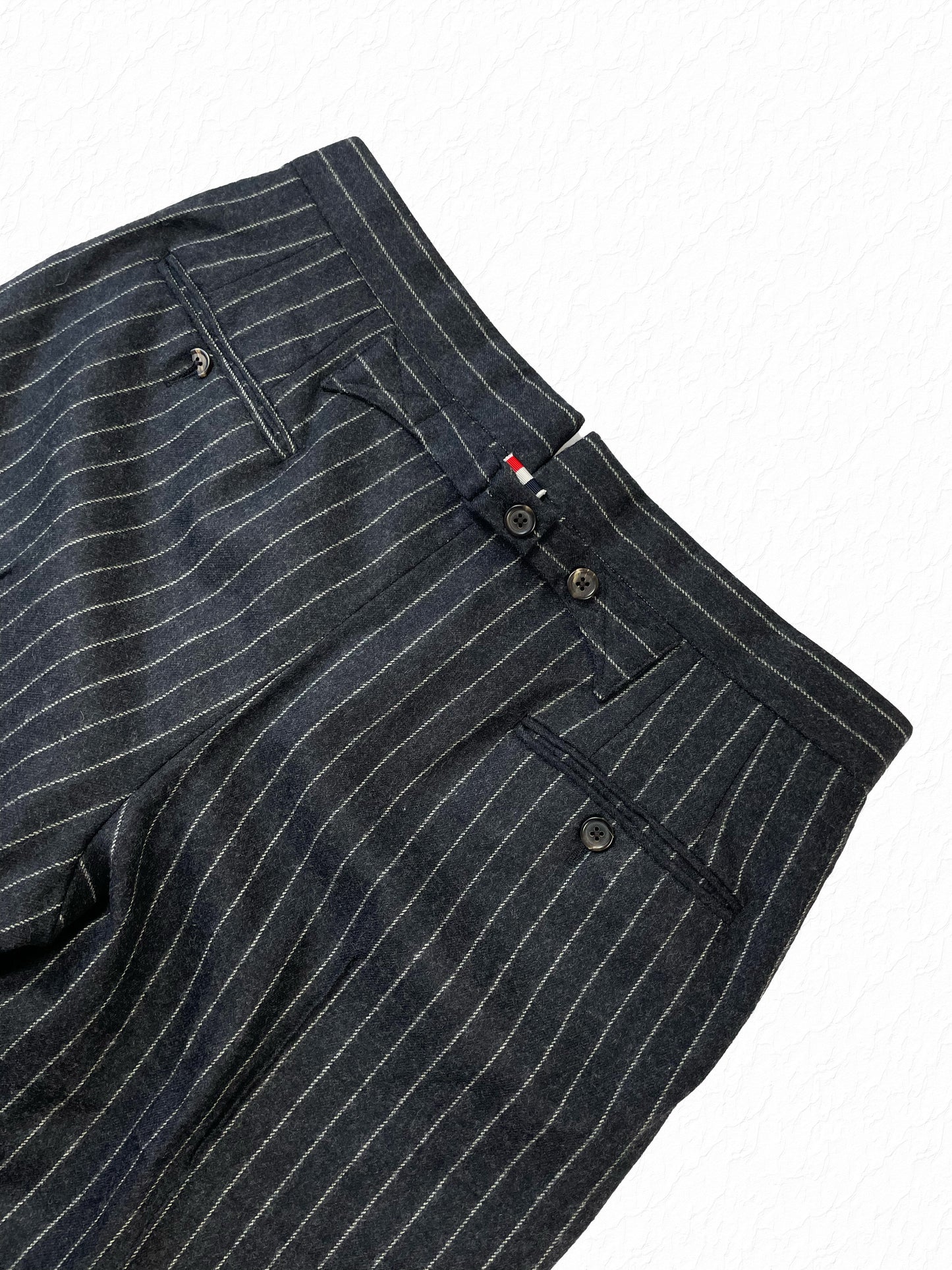 Rear welt pocket detailing on Thom Browne grey pinstripe wool trousers
