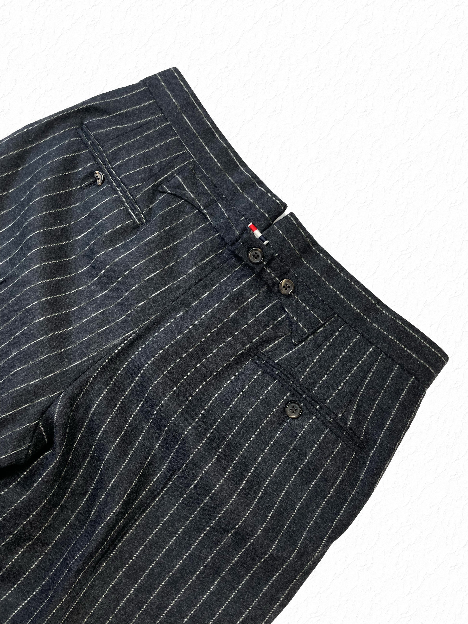 Rear welt pocket detailing on Thom Browne grey pinstripe wool trousers