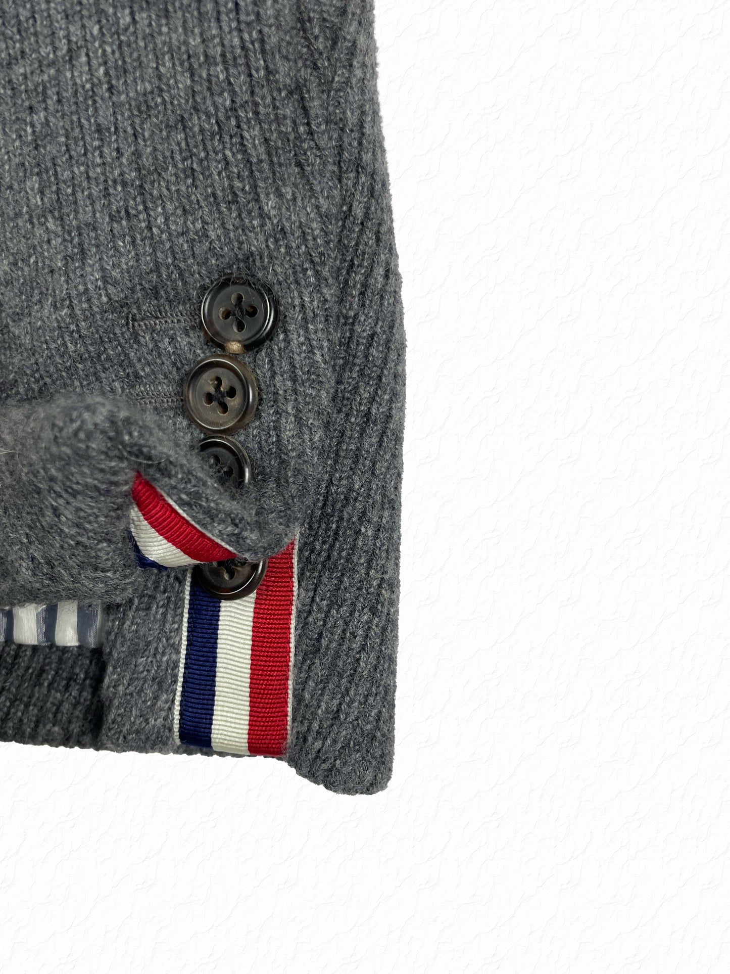 Red white and blue grosgrain tab on Thom Browne cashmere jacket