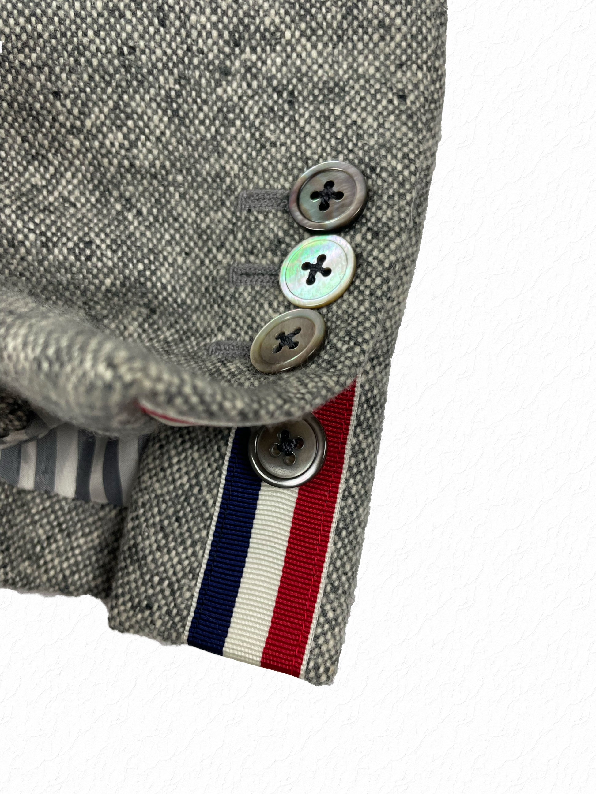 Mother of pearl four-hole buttons and RWB grosgrain tab on Thom Browne tweed blazer