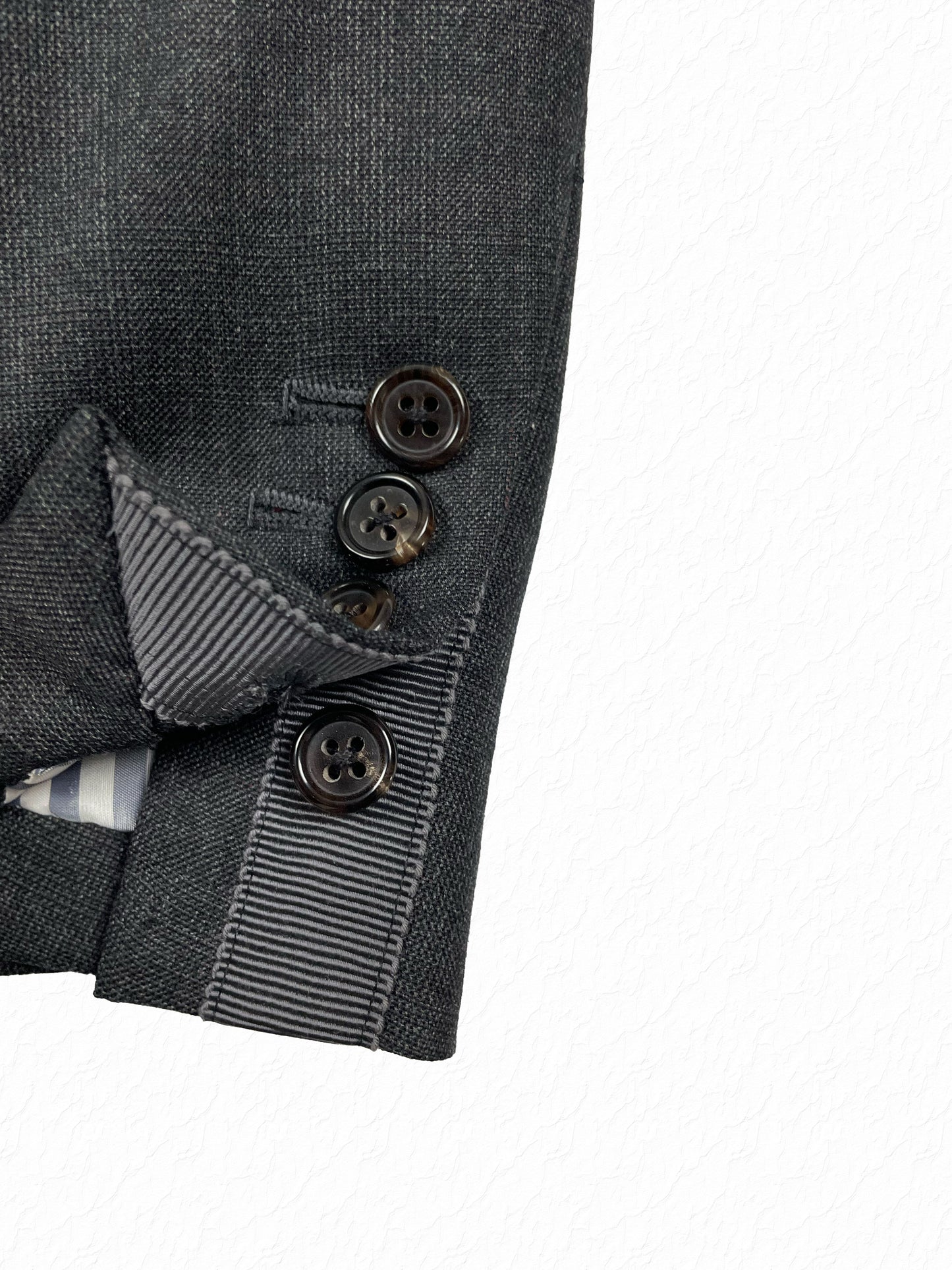 Grosgrain tab cuff on Thom Browne grey wool blazer with four hole buttons