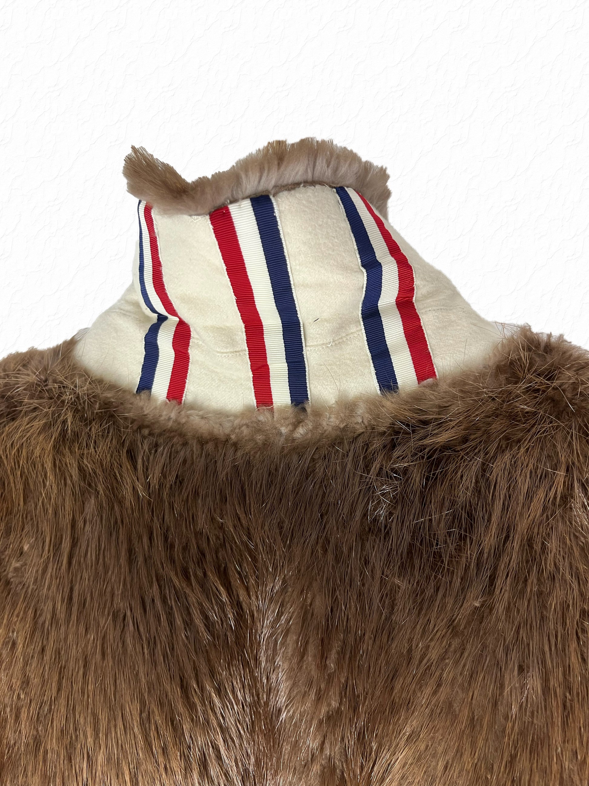 Three RWB grosgrain ribbons at the collar of Thom Browne beaver fur coat