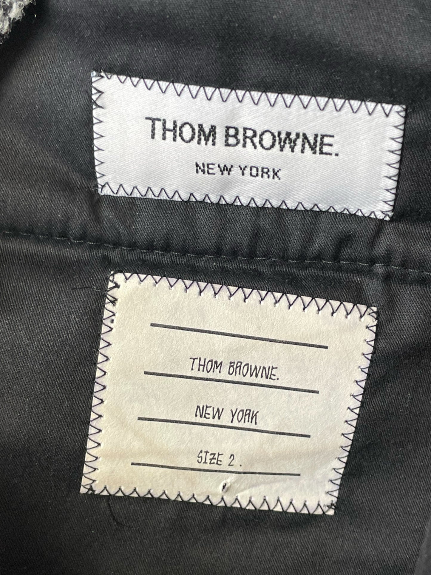 Herringbone tweed weave on Thom Browne grey wool trousers