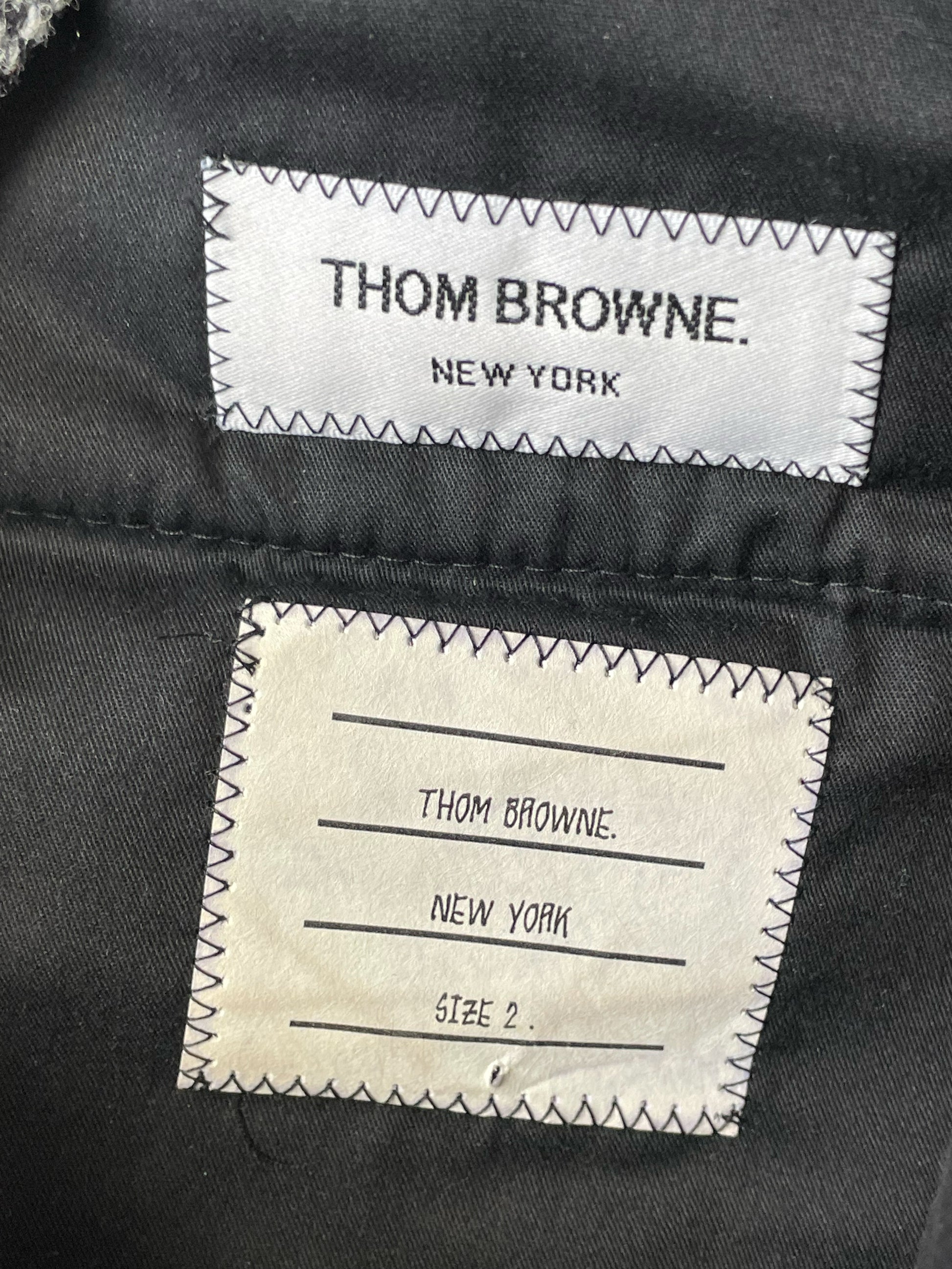 Herringbone tweed weave on Thom Browne grey wool trousers
