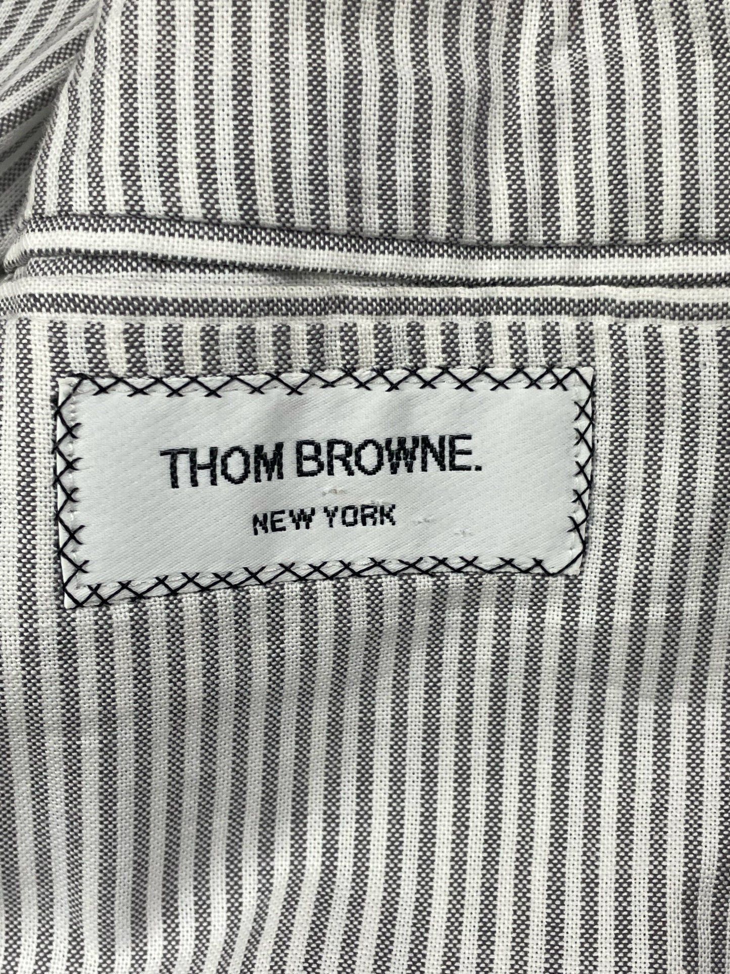 Thom Browne New York woven brand label on striped cotton lining