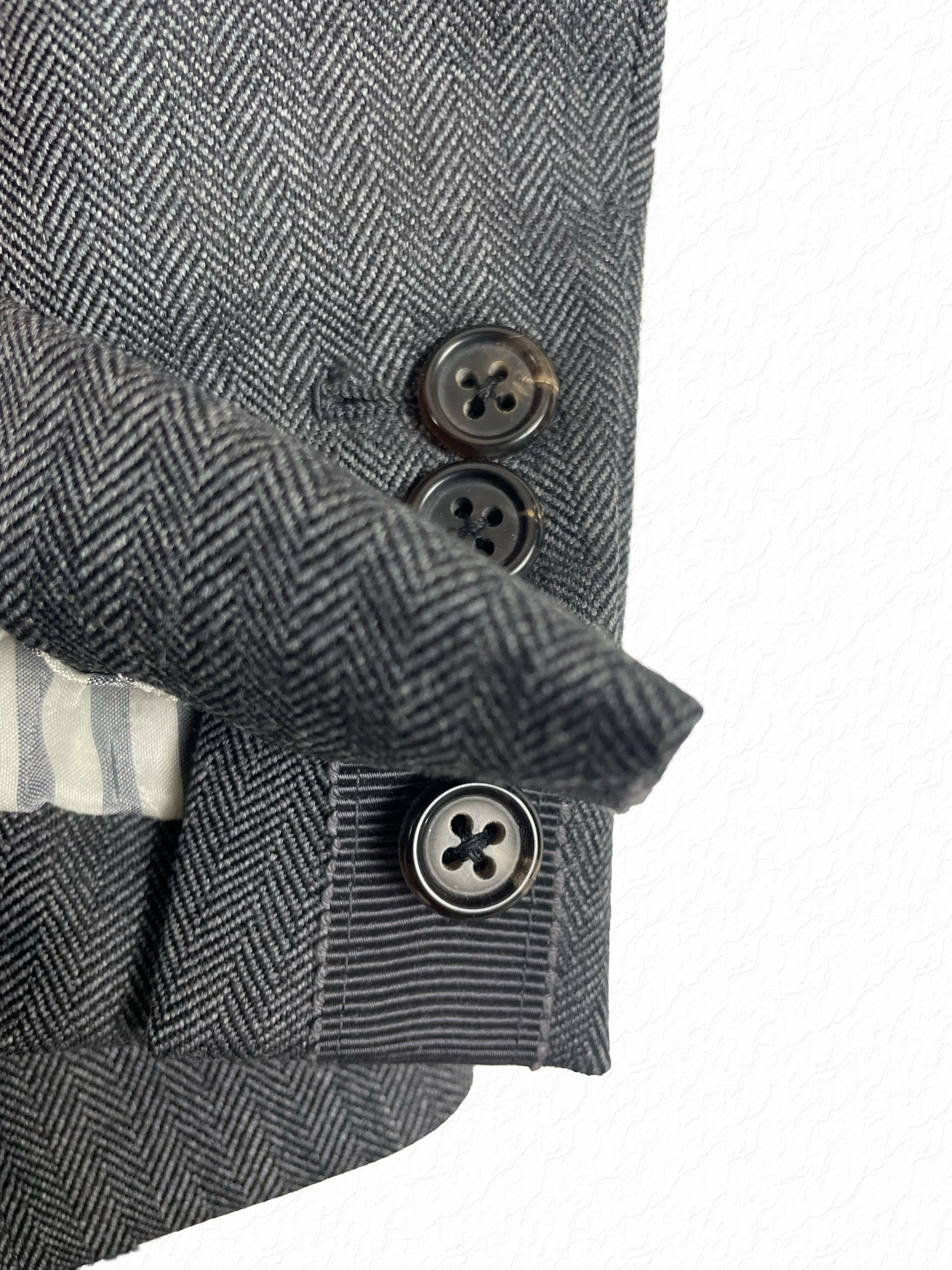Herringbone wool sleeve with four working buttons on Thom Browne blazer
