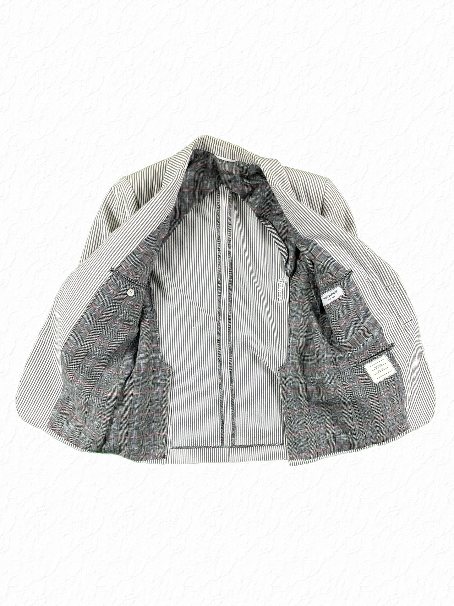 Prince of Wales check lining on Thom Browne seersucker blazer