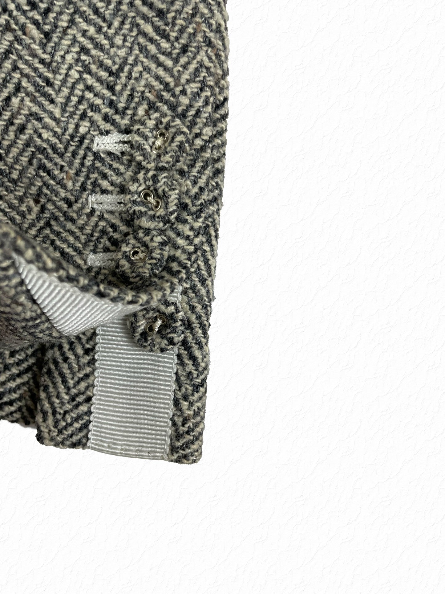 Grosgrain tab detailing on Thom Browne herringbone tweed sport coat sleeve