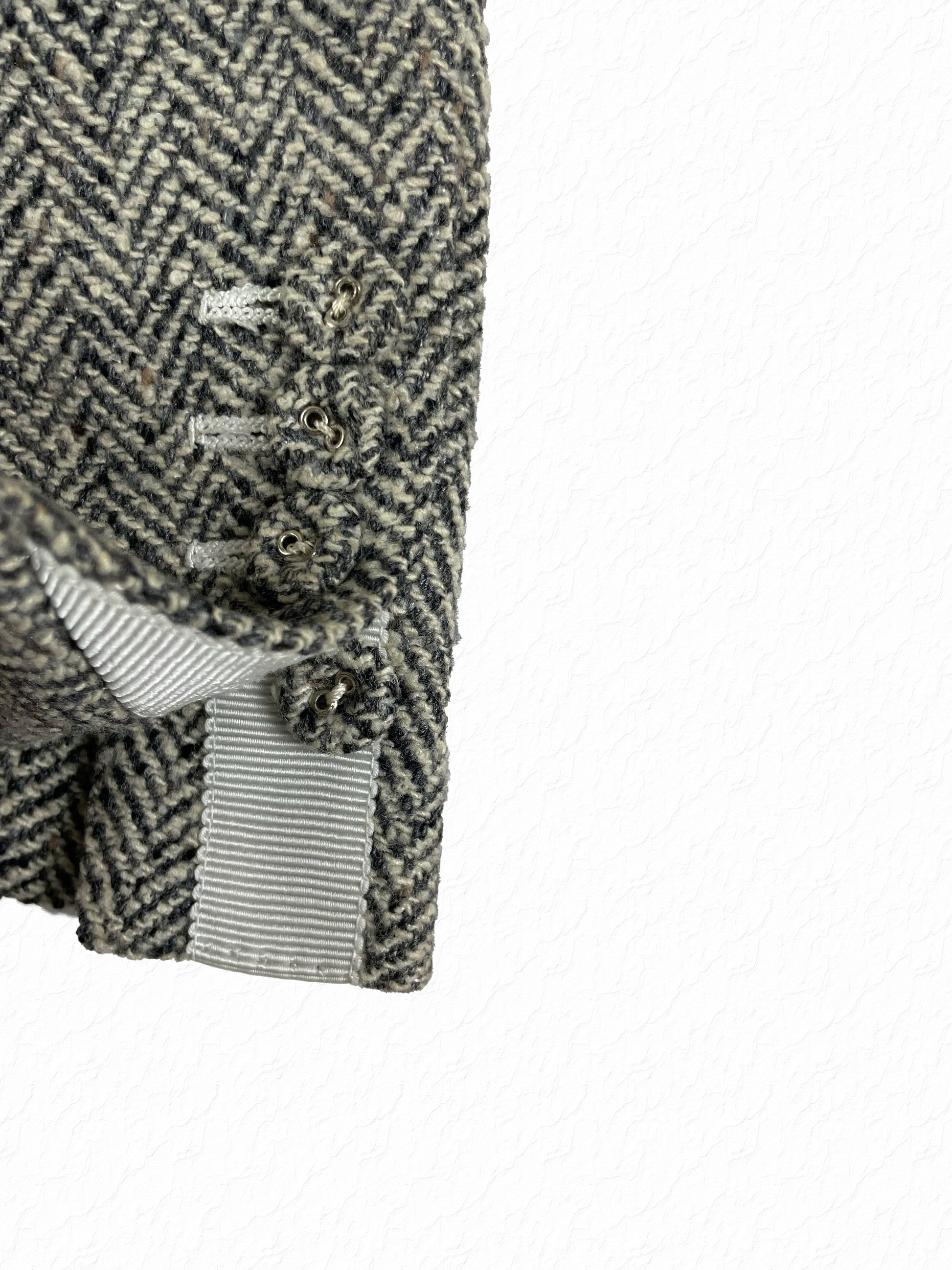 Grosgrain tab detailing on Thom Browne herringbone tweed sport coat sleeve